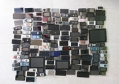 Gesammelte Handys liegen in Reihen auf einem Tisch