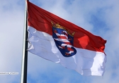 Flagge von Hessen: Querformat, oben rot unten weiß, in der Mitte auf blauem Grund ein weiß-rot gestreifter aufgerichteter Löwe