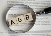 Durch eine Lupe sieht man die drei Buchstaben AGB